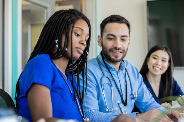 istock Group of medical professionals sitting at a conference table 1209368402