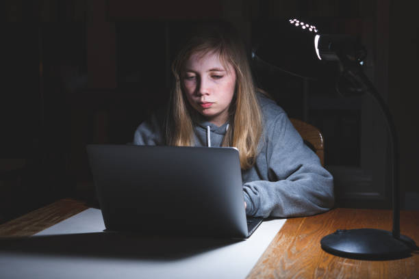 boring homework pictures Sad/unhappy teen girl working/studying. Sad/unhappy teen girl working/studying with a laptop at night on a desk. boring homework twelve stock pictures, royalty-free photos & images