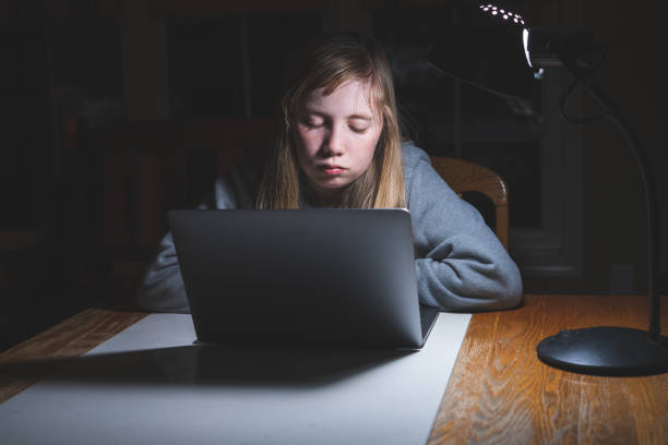 Sad/unhappy teen girl working/studying. stock photo