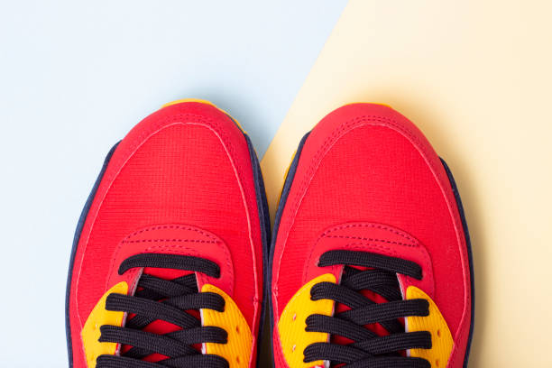 istock Red sneakers on a blue and yellow background close up top view, copy space 1209374489