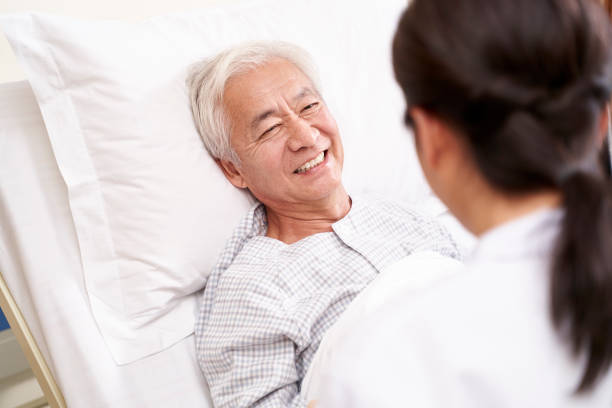 senior asian patient talking to medical worker