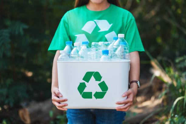 istock A woman collecting garbage and holding a recycle bin with plastic bottles 1209378202