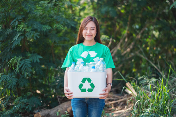 istock woman collecting garbage and holding a recycle bin with plastic bottles 1209378235