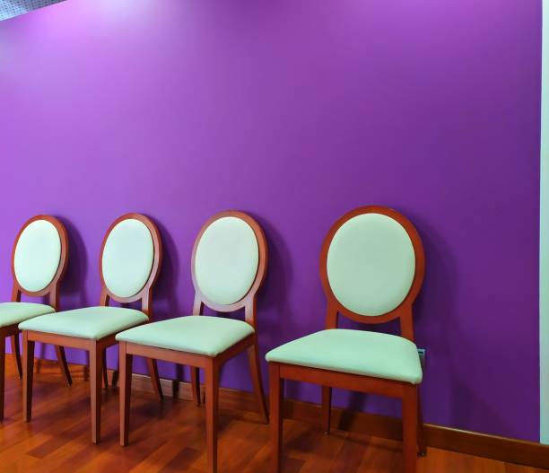 Inside, four chairs. Purple wall. Inside of funeral home, rest area for family funeral home chairs stock pictures, royalty-free photos & images