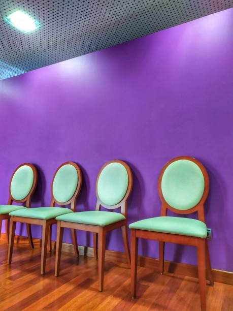 Inside, four chairs. Purple wall. Inside of funeral home, rest area for family funeral home chairs stock pictures, royalty-free photos & images