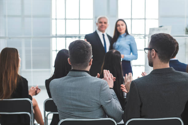 istock rear view. company employees applauding at a work meeting 1209388376