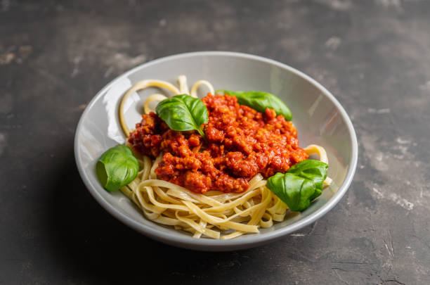 istock Traditional pasta bolognese with beef and tomatoes the rustic background 1209389420