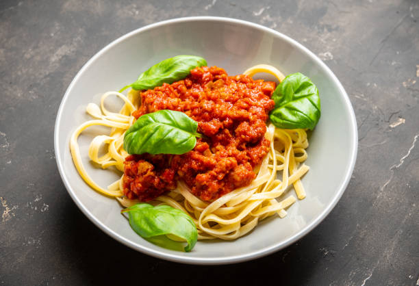 istock Traditional pasta bolognese with beef and tomatoes the rustic background 1209389425