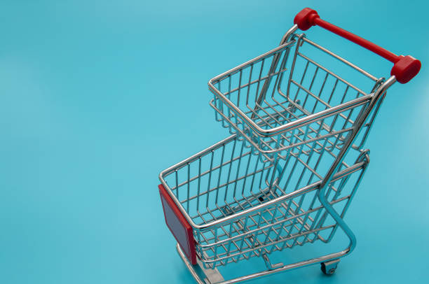 istock Empty shopping cart on blue background 1209390160