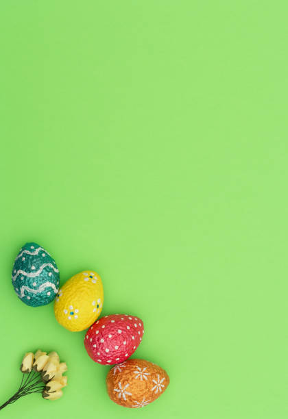 istock Colorful painted orange, blue, red and yellow Easter eggs with yellow spring flowers on green background. Happy Easter holiday concept. Flat lay style with copy space. 1209397163