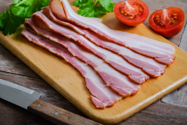 istock Raw sliced bacon on wooden board 1209399094