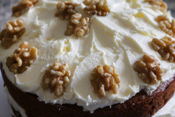 imagem de close-up de cenoura caseira e bolo de frutas de nozes, coberto com cobertura de manteiga de queijo creme, decorado com metades de nozes - gateaux cake birthday decorating - fotografias e filmes do acervo