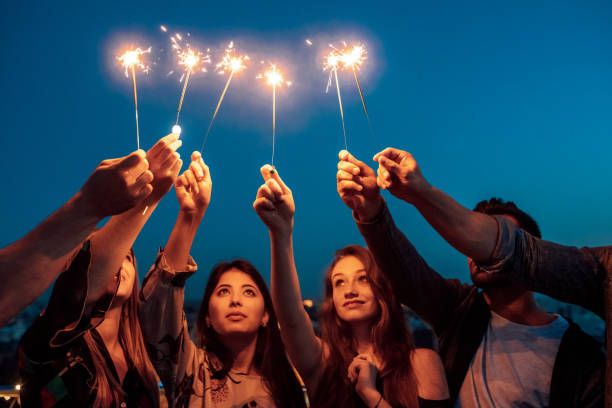 istock people hands holding sparklers against sky. 1209406858