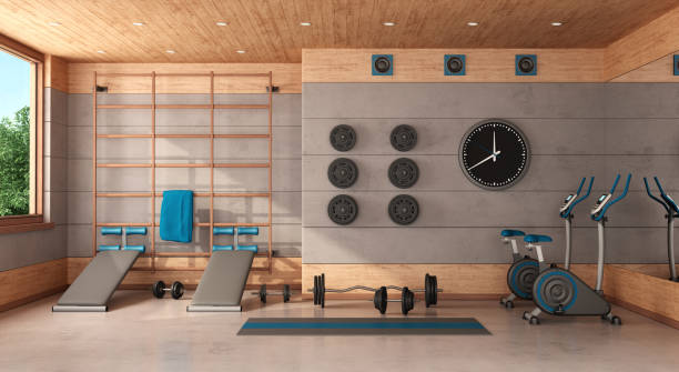 Home gym in a concrete and wooden room Home gym with Swedish  wall, bench, bicycle and weights - 3d rendering exercise room stock pictures, royalty-free photos & images