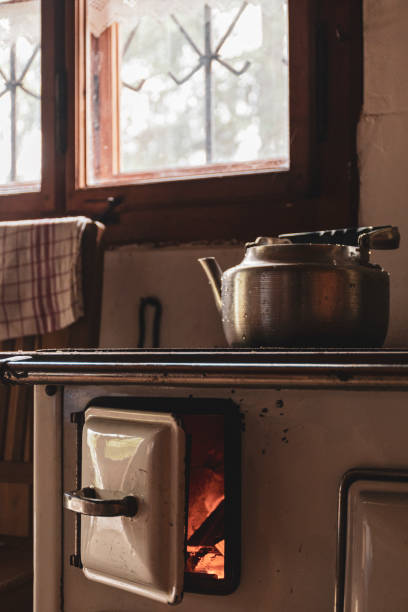 istock old stove with open hatch and burning fire in a simple cabi 1209415802