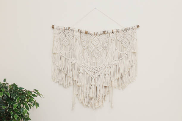 istock Macrame wall panel made of natural cotton threads on a light wall. for home decor in the style of Boho. 1209417889