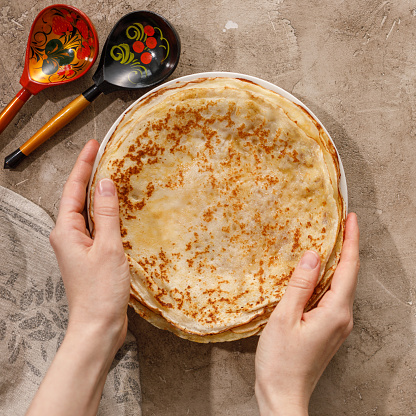 Delicious homemade pancakes with honey on a textural background. Top view, close-up. Traditional holiday celebration concept. Russian translation wide and happy Maslenitsa.