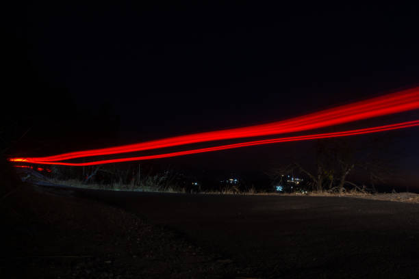 istock Long Exposure shot of a car in motion leaving light trails. 1209419384