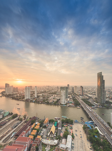 Skyscrapers and small traffic routes along the Chao Phraya River in Bangkok as seen from the Taksin Bridge at night. Bangkok,