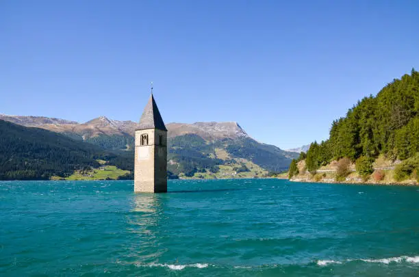 Bell tower in Lake Reschen (Reschensee) in Curon Venosta, Trentino Alto Adige / Suedtirol (South Tyrol), Italy