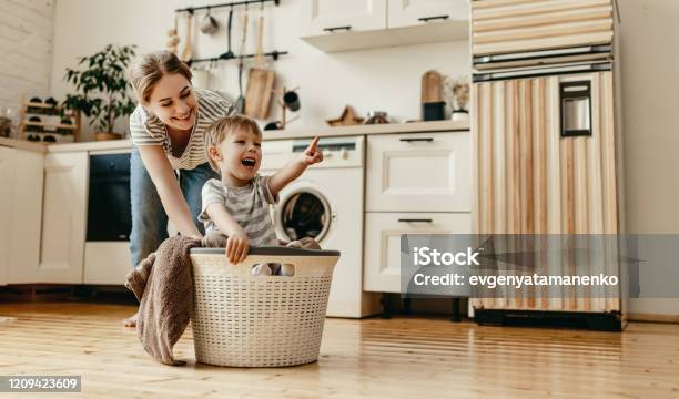 Happy Family Mother Housewife And Child In Laundry With Washing Machine Stock Photo - Download Image Now