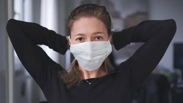 horizontal background of woman wearing surgical mask for corona virus isolation .