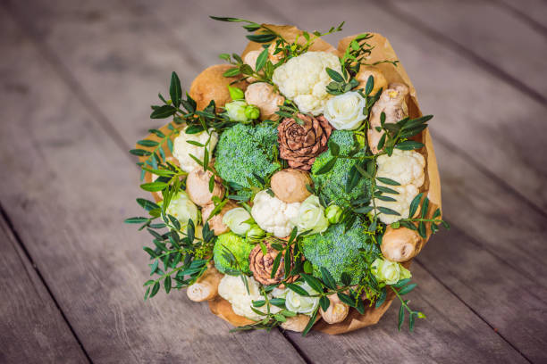 Bouquet of vegetables and fruits, useful gift for a healthy lifestyle, a detox diet. broccoli, cauliflower, ginger, cedar cone Bouquet of vegetables and fruits, useful gift for a healthy lifestyle, a detox diet. broccoli, cauliflower, ginger, cedar cone. broccoli crowns stock pictures, royalty-free photos & images