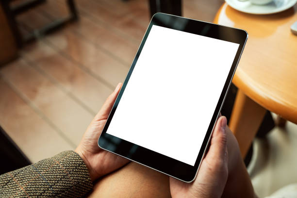 istock a woman sitting and holding black tablet pc with blank white desktop screen 1209424751