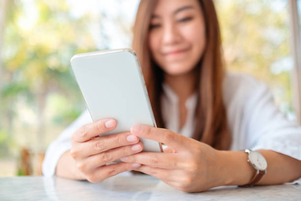 istock a beautiful asian woman holding and using mobile phone in cafe 1209424779