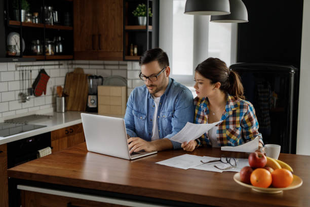 istock Young couple working on their finances together at home 1209425004