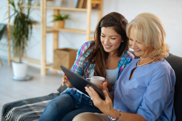 istock Senior mother and her daughter browsing internet on tablet 1209425112