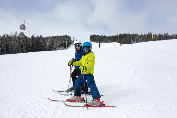 child, skiing in winter ski resort on a sunny day, enjoying sports in nature - czech republic ski winter skiing imagens e fotografias de stock