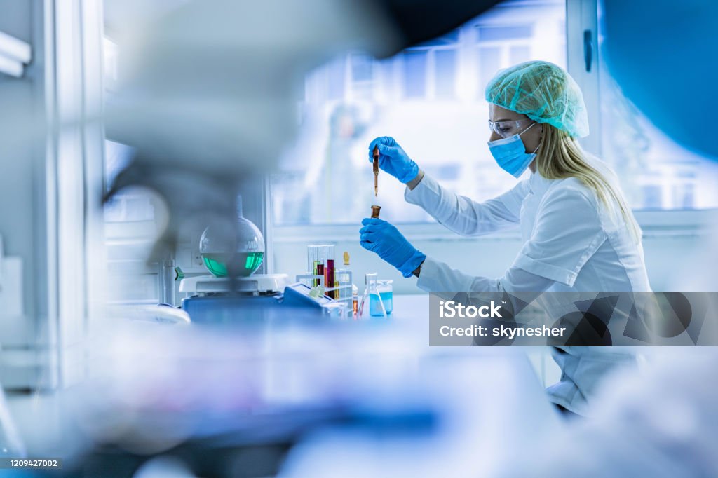 実験室で有毒な液体を調べる女性科学者。 - 実験室のロイヤリティフリーストックフォト
