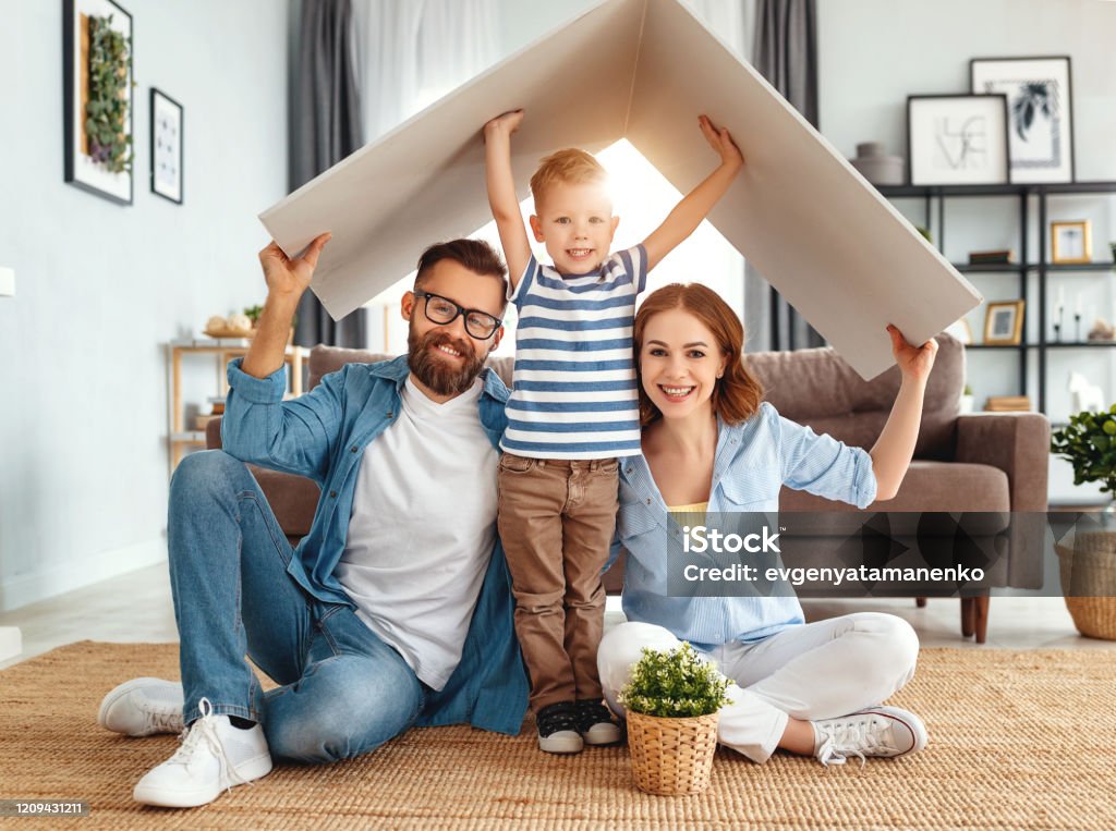 Konzept für junge Familie. Mutter Vater und Kind in neuem Haus mit Dach zu Hause - Lizenzfrei Familie Stock-Foto