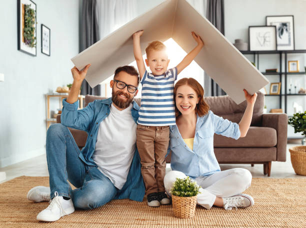 concept abritant la jeune famille. père et enfant de mère dans la nouvelle maison avec le toit à la maison - child beauty mother little boys photos et images de collection