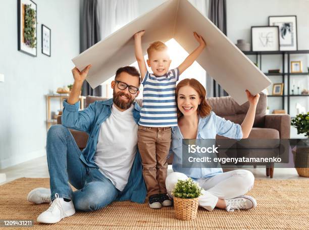 Concept Housing Young Family Mother Father And Child In New House With Roof At Home Stock Photo - Download Image Now