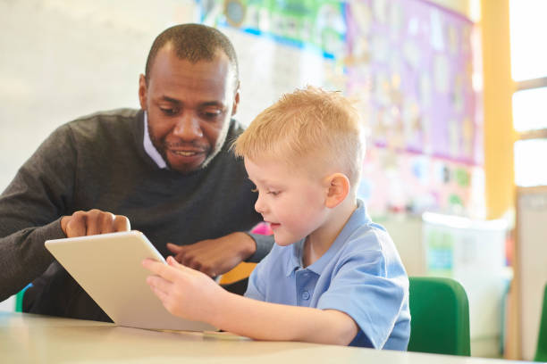 digital tablet in the classroom - polo shirt two people men working imagens e fotografias de stock