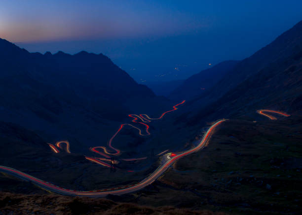 istock Transfagarash road bay night car trails 1209436234