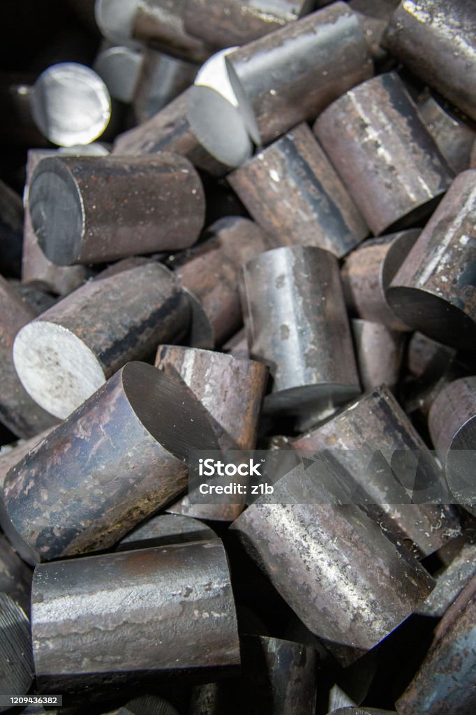 a pile of raw steel short rods cutted by saw - workpieces prepaired for forging, close-up with selective focus a pile of raw steel short bars cutted by saw - workpieces prepaired for forging, close-up with selective focus and background blur Ingot Stock Photo