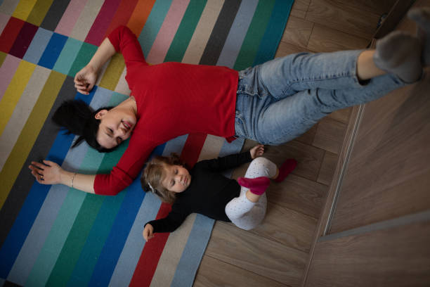 istock Young mother and her daughter lying on the floor 1209437415