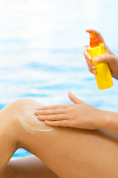 istock Woman applying sunblock cream on her legs. 1209440843