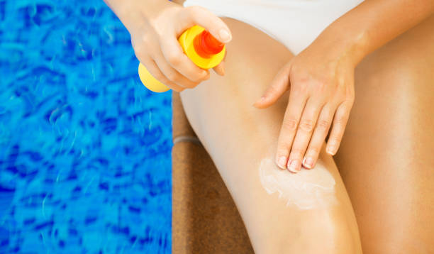 istock Woman applying sunblock cream on her legs. 1209440850