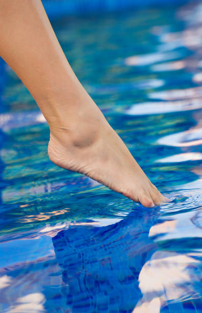 istock Woman checking water in the swimming pool. 1209440879