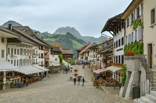 Gruyeres, Switzerland - June 9, 2019: Historic town square in small city Gruyeres in canton of Fribourg, Switzerland during cloudy morning day in June 2019