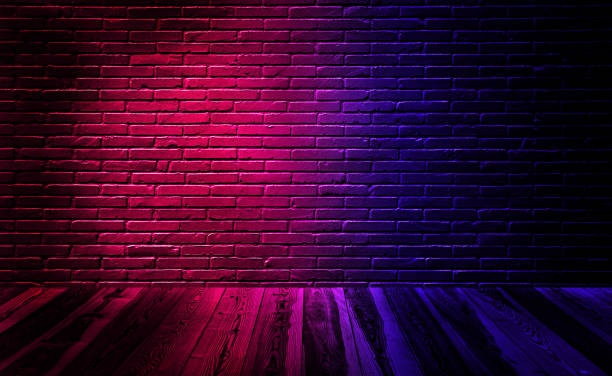 istock Empty studio dark room black brick wall with wooden floor and lighting effect red and blue. 1209442881