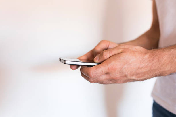 istock man hands holding a smartphone over white background. Lifestyle 1209445627