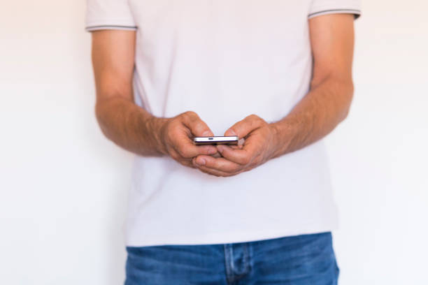 istock man hands holding a smartphone over white background. Lifestyle 1209445642