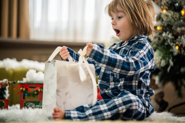 Close up boy on the floor with gift Cute little boy have surprise gift for Christmas christmas excitement stock pictures, royalty-free photos & images