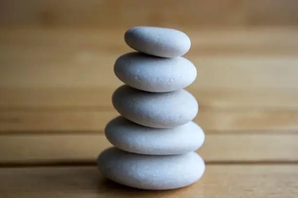 Photo of Harmony and balance, cairns, simple poise stones on white background, rock zen sculpture, white pebbles, single tower, simplicit