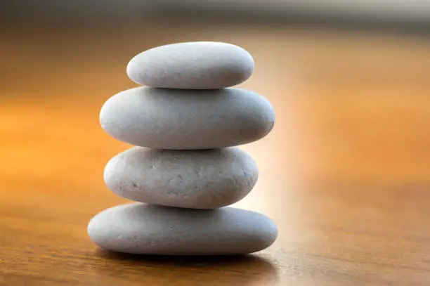Photo of Harmony and balance, cairns, simple poise stones on white background, rock zen sculpture, white pebbles, single tower, simplicit